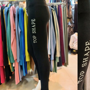 picture of black leggings printed with a white logo on the thigh: Top Shape. bikinn.com