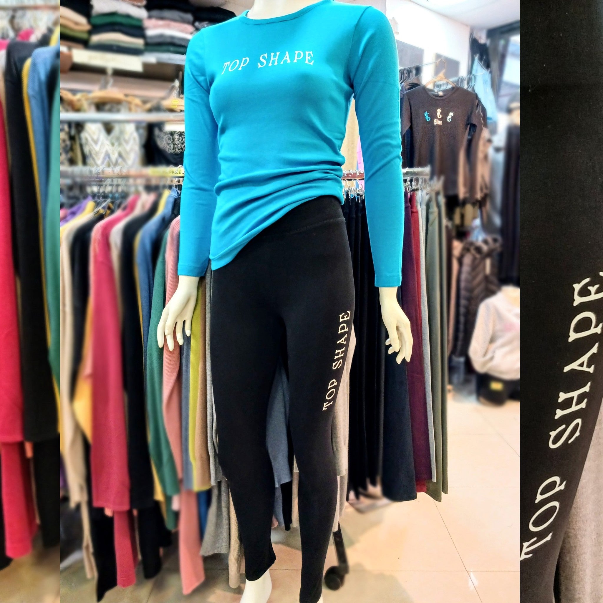 picture of a manequin in a store wearing a black leggings printed with a white logo on the thigh: Top Shape, and a long sleeves blue tee-shirt with the same logo on the front.  bikinn.com