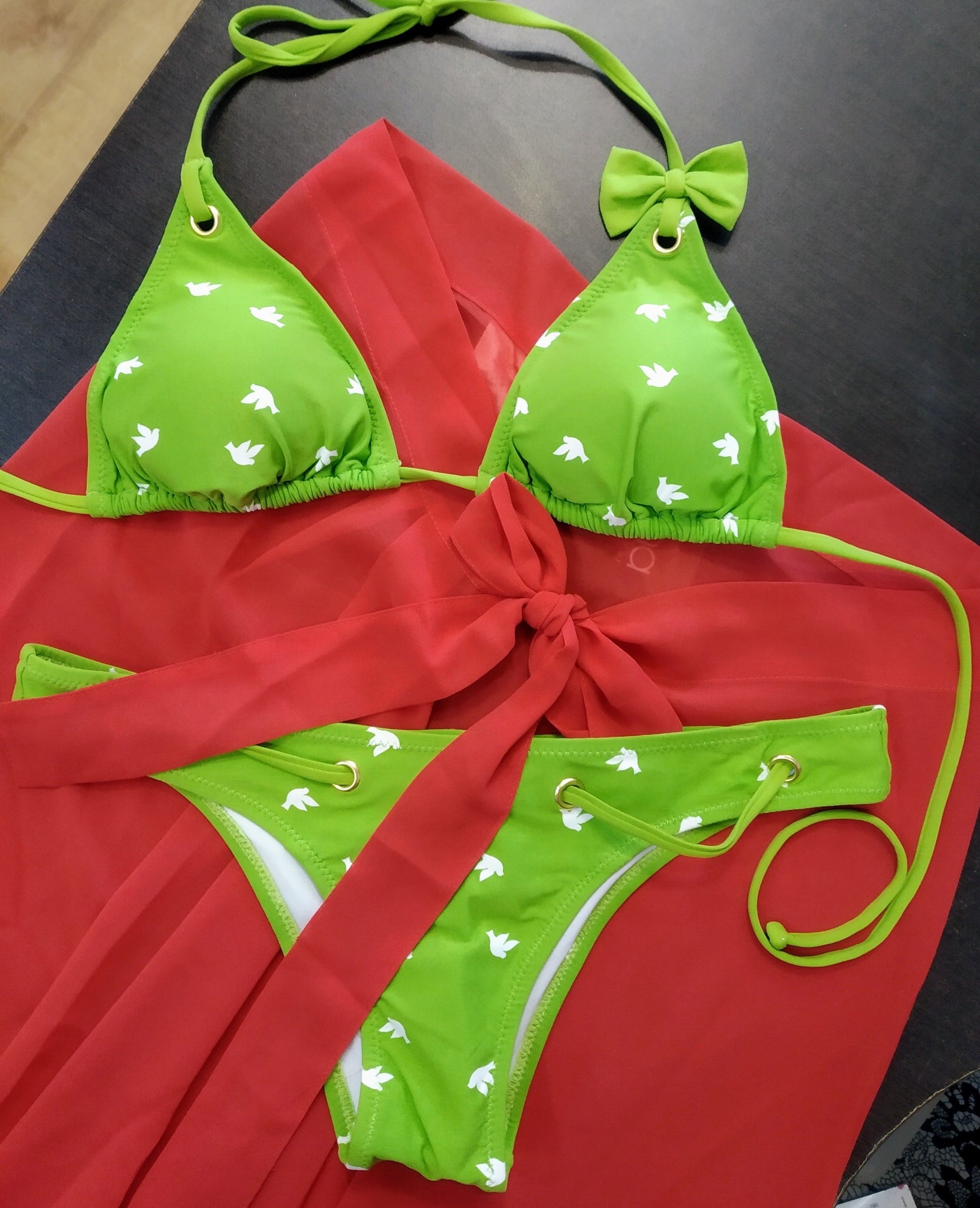 green triangle bikini set photographed on a red pareo. bikinn.com