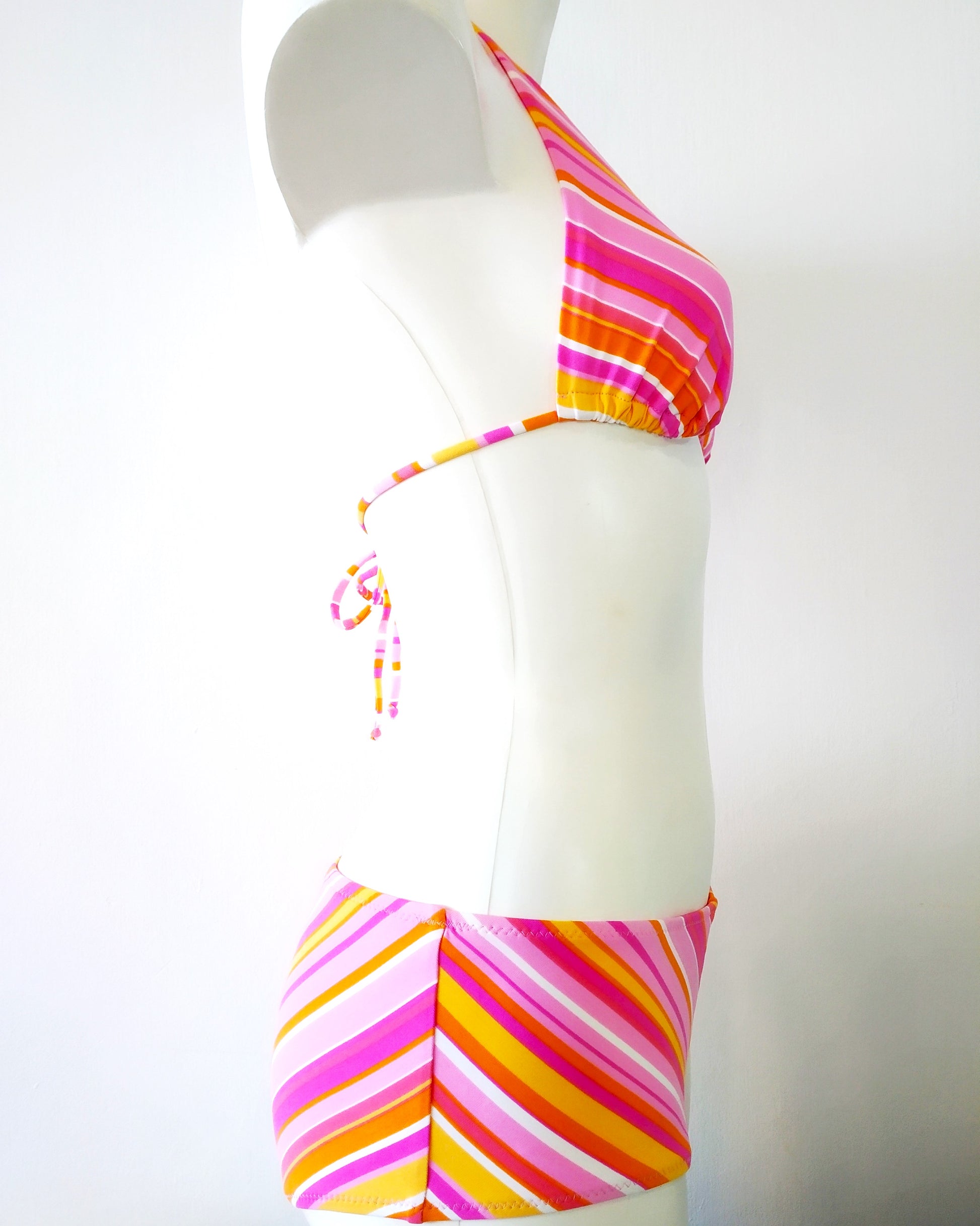 side view of a bikini set pastel-colored stripes pattern with large size of shorty bikini bottom and triangle halter bikini bra.