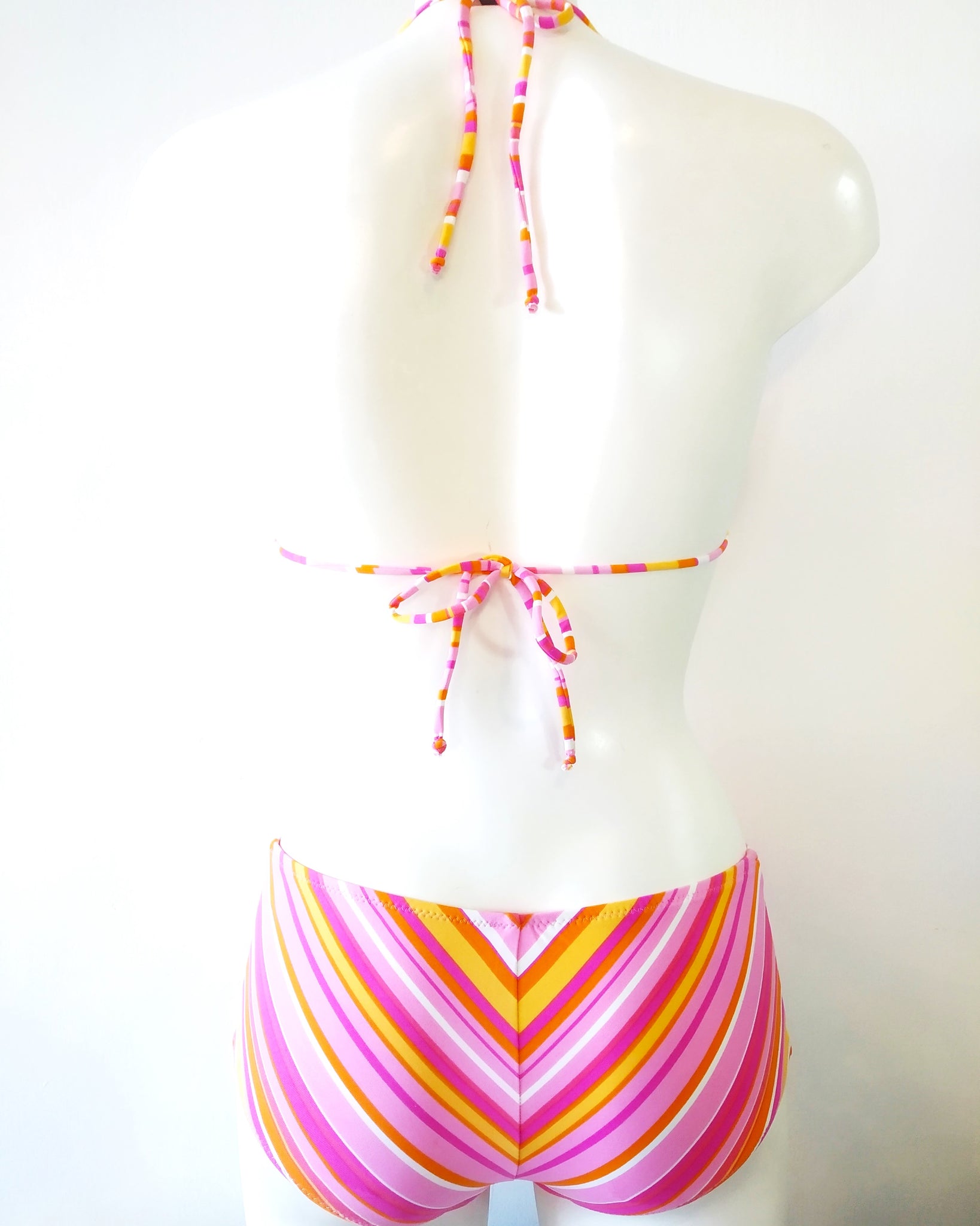 back view of a bikini set pastel-colored stripes pattern with large size of shorty bikini bottom and triangle halter bikini bra.