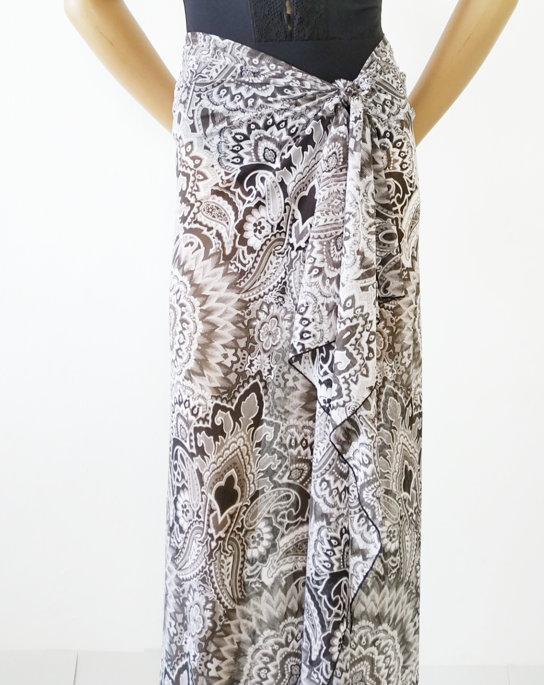 Maxi sarong in stretch lycra veil with floral mosaic print  Black / White, tied around the waist as a long maxi skirt. Bikinn.com