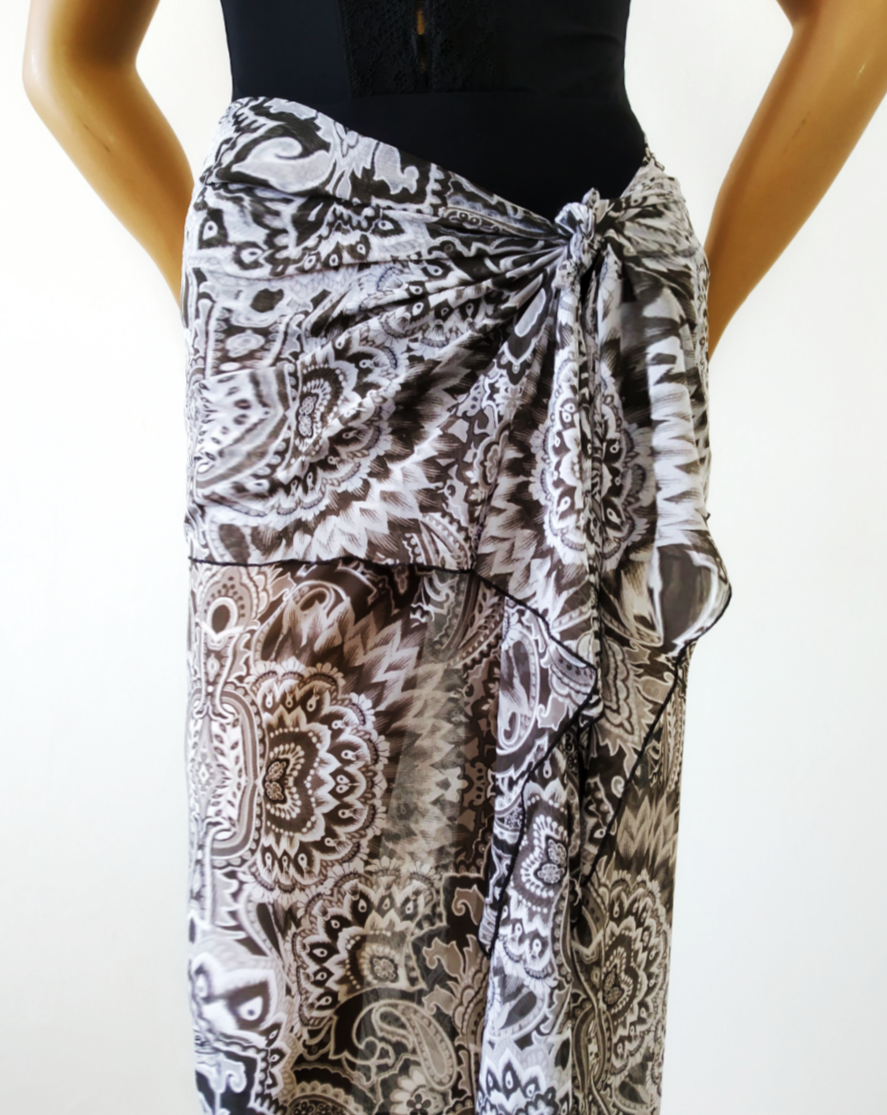 Maxi sarong in stretch lycra veil with floral mosaic print  Black / White, tied around the hips in a pareo beach skirt way. Bikinn.com