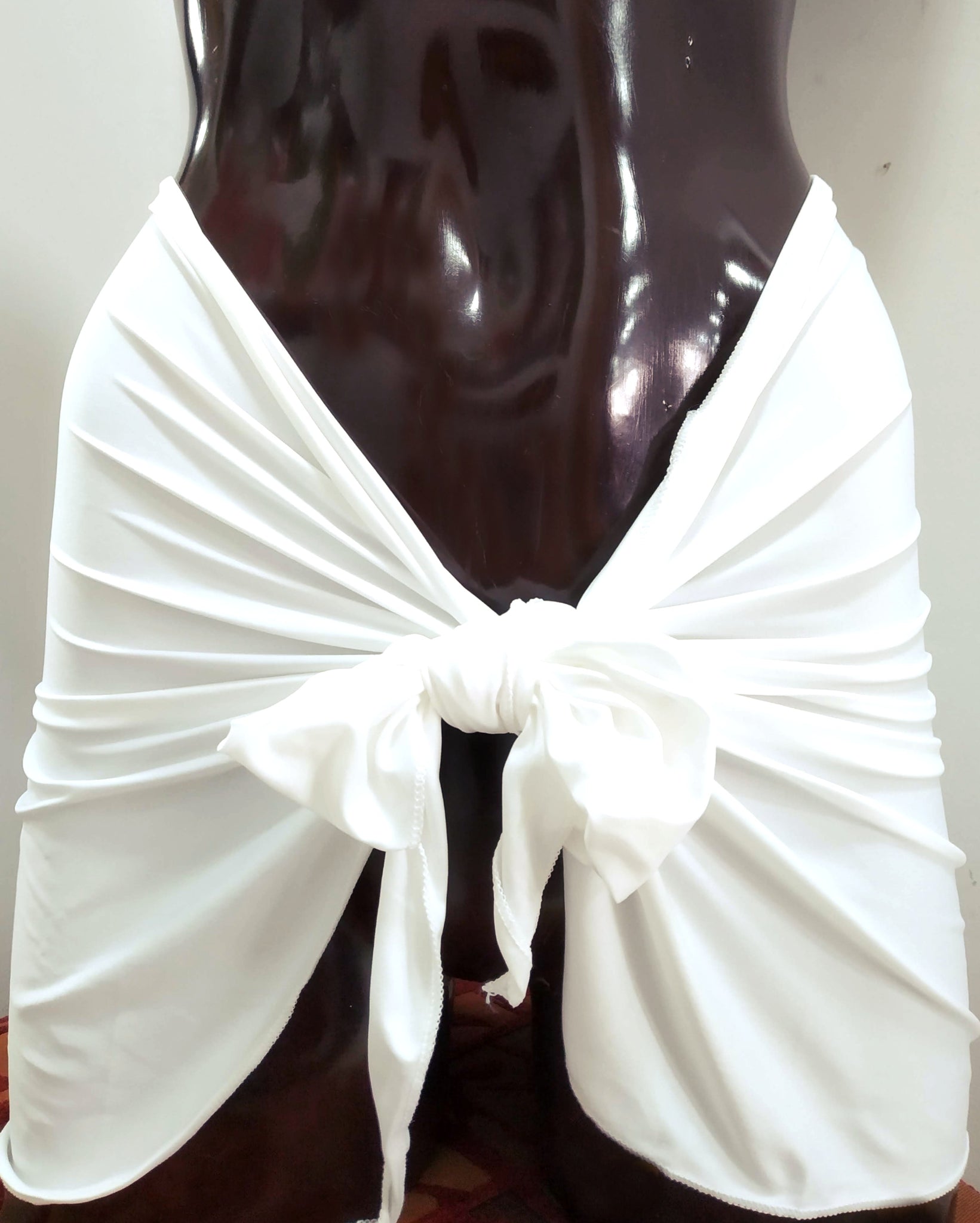 white mini pareo stretchy cover-up sarong tied around a brown mannequin. beachwear at bikinn.com