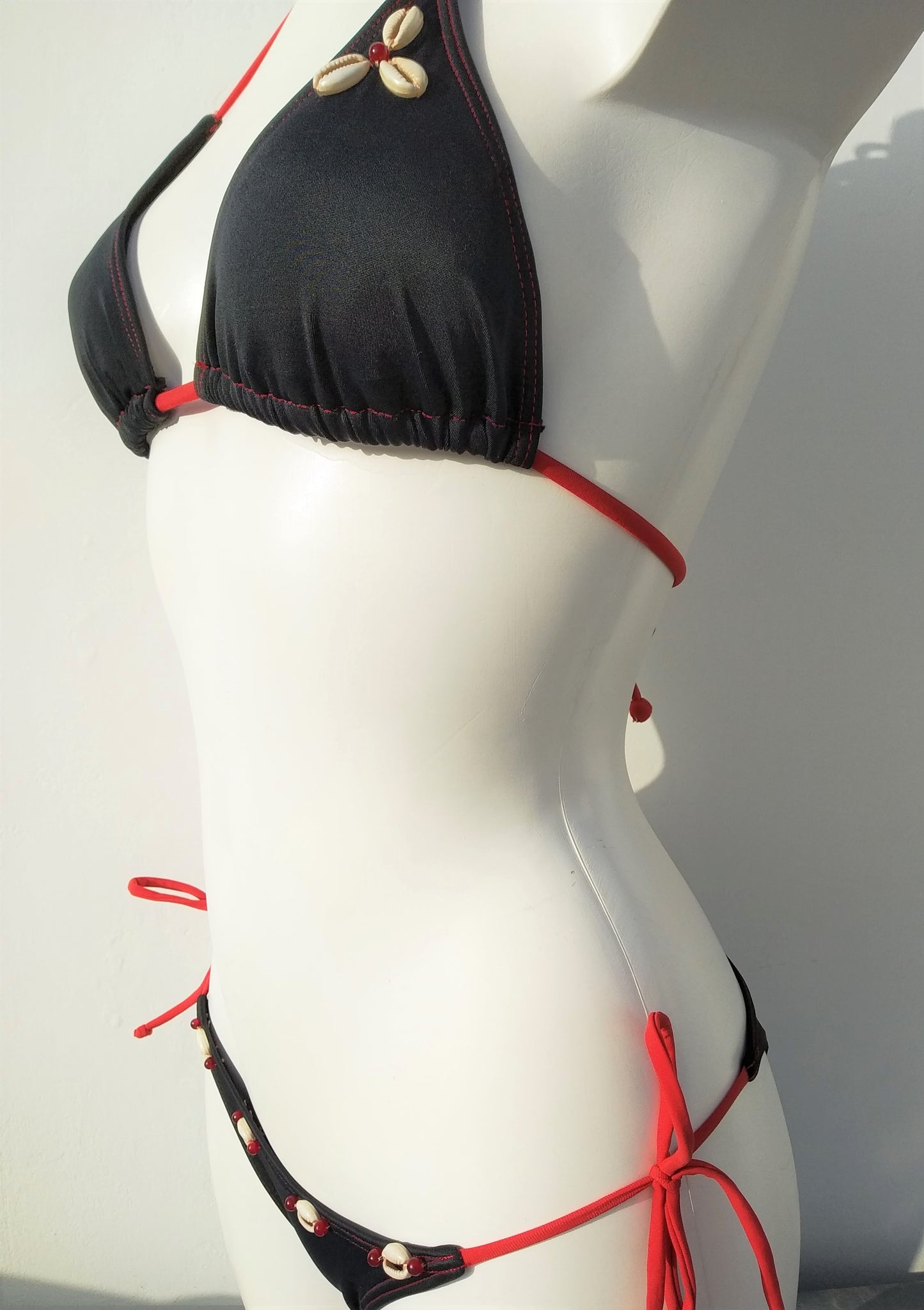 profile view of triangle bikini set with black tie-side bikini bottom with seashells embellishment. bikinn.com
