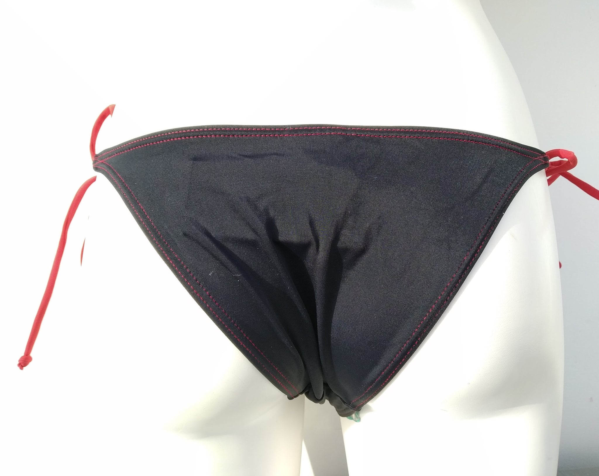 back view of black tie-side bikini bottom with seashells embellishment. bikinn.com