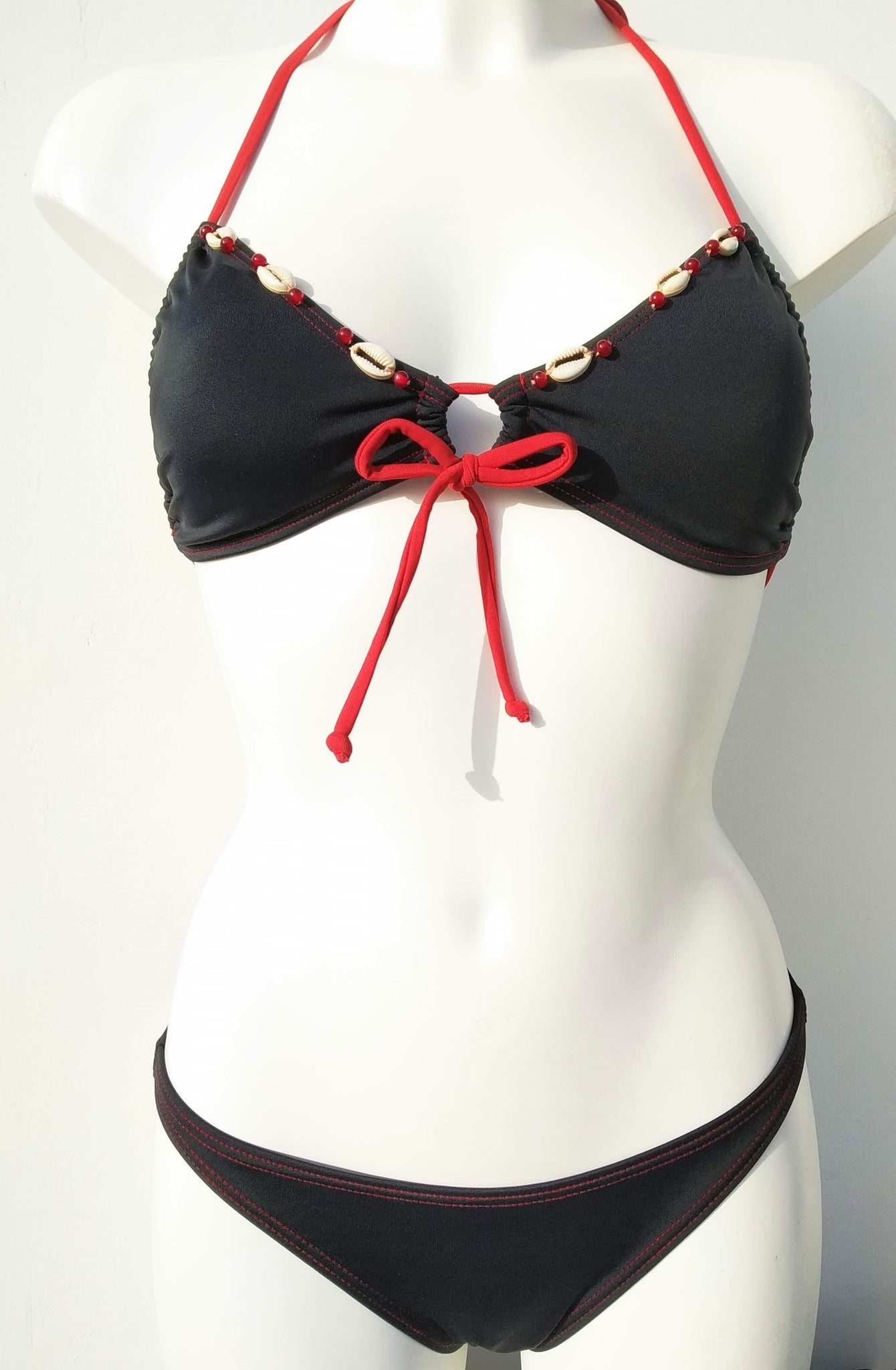 reversed black triangular bikini set  with few seashells sewn for decoration along the neckline . bikinn.com