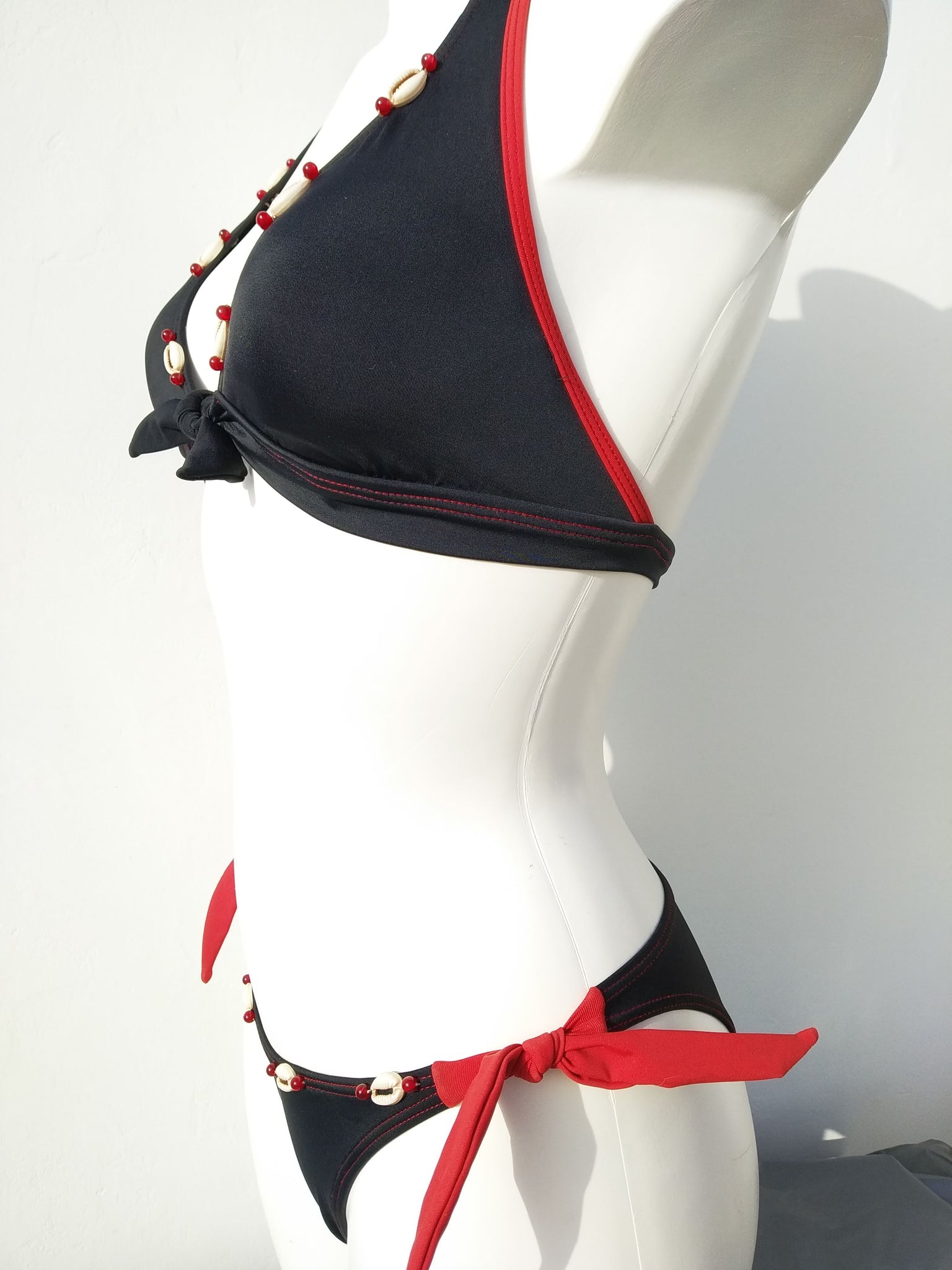 profile view of a black Halter bikini set with seashells decoration along the neckline, mix and match collection. bikinn.com