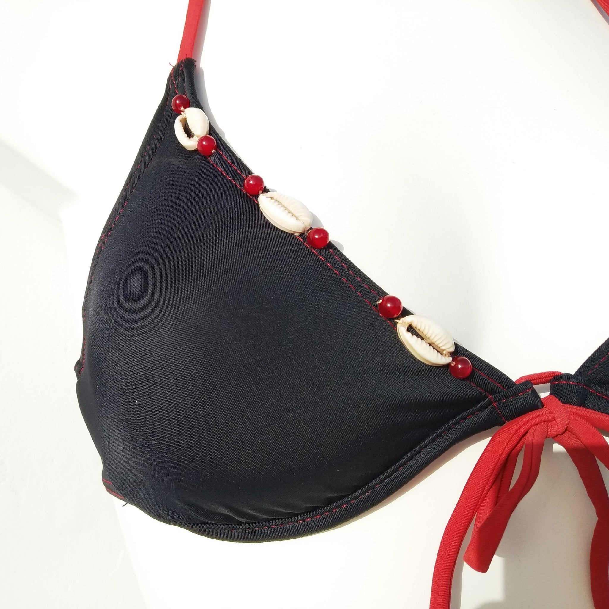 Close-up of black bikini underwired bra with seashells decoration, mix and match collection