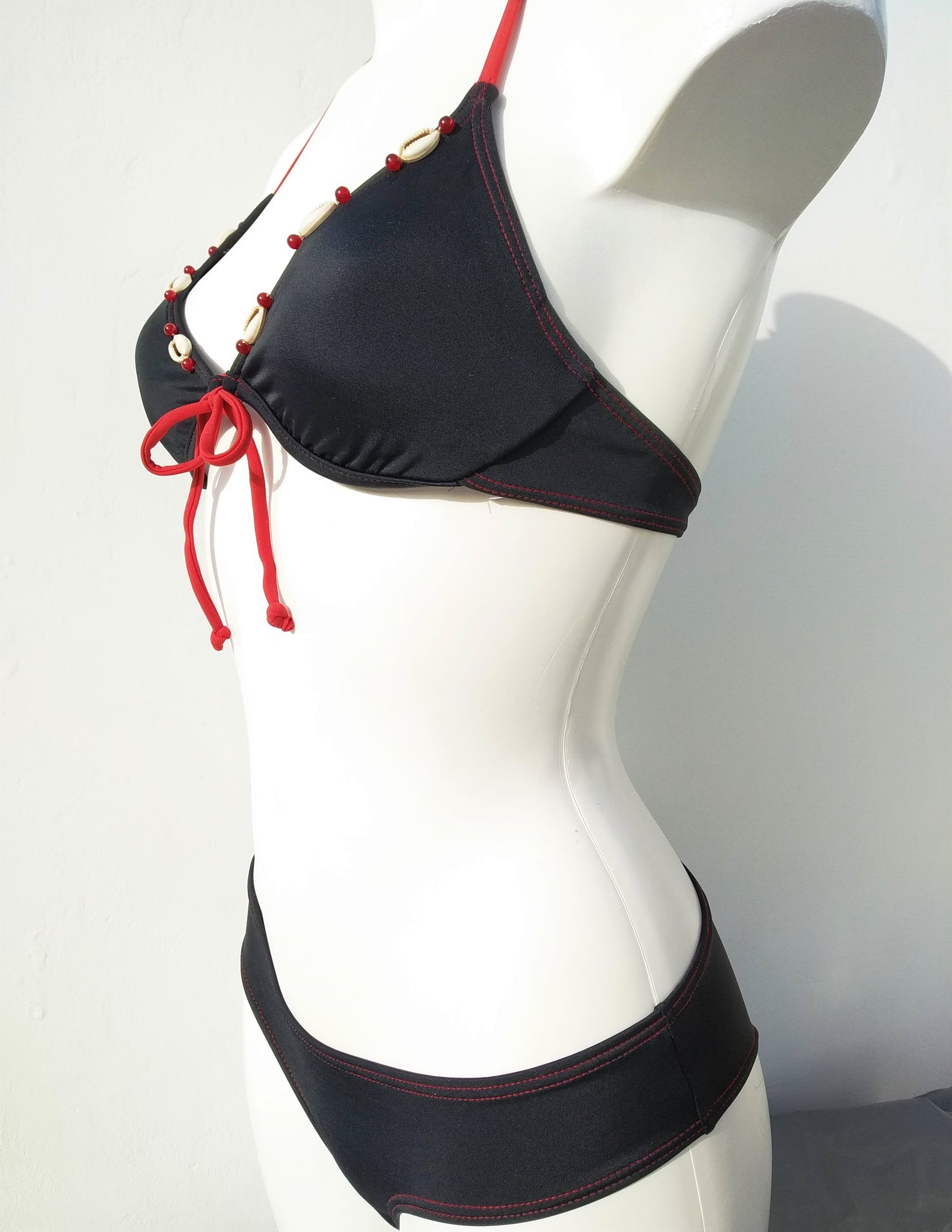 profile view of black bikini set, underwired bra , low cut bottom, with seashells decoration, mix and match collection