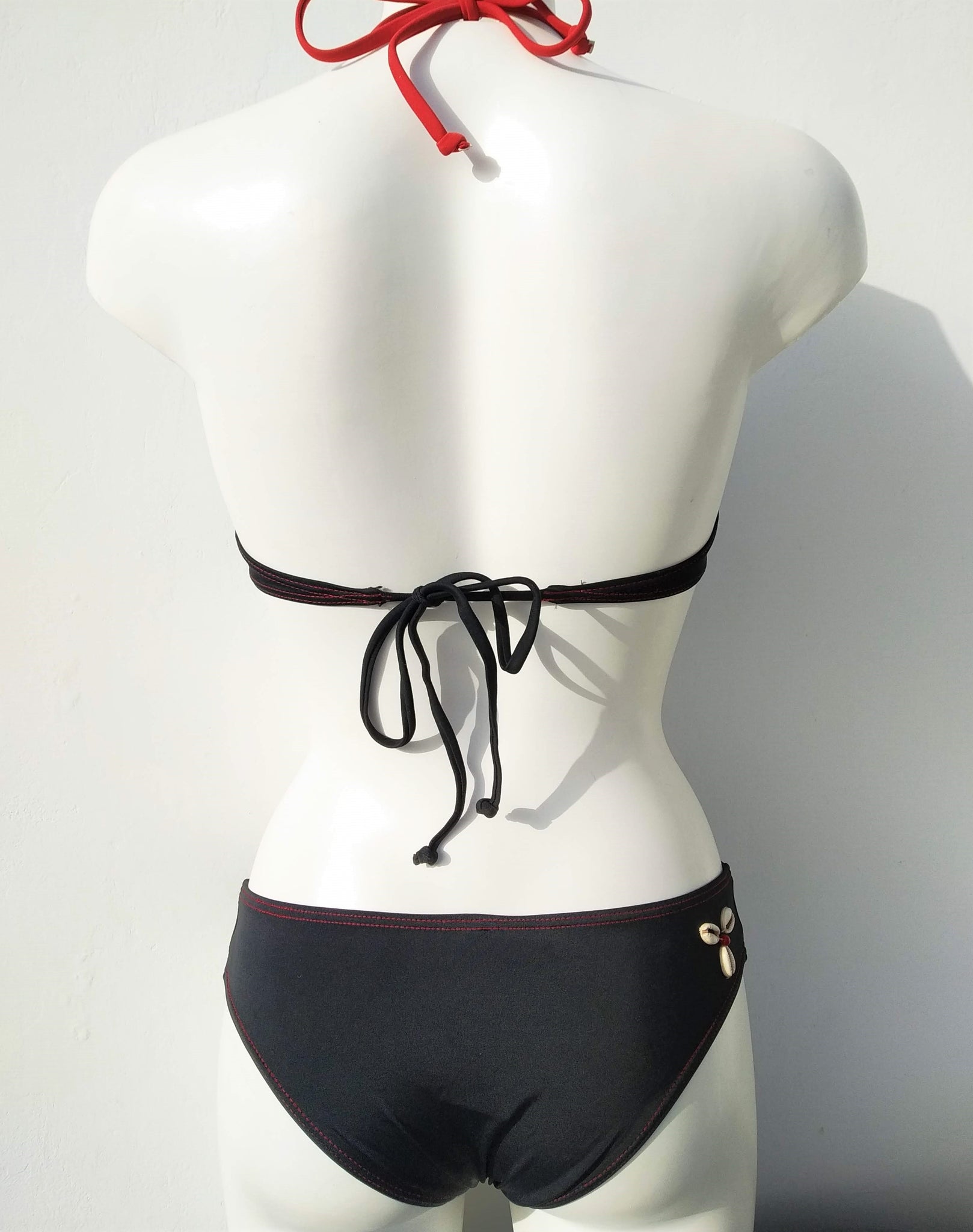 Back view of black bikini set underwired bra and low bottom, cheeky bottom with seashells decoration, mix and match collection. bikinn.com