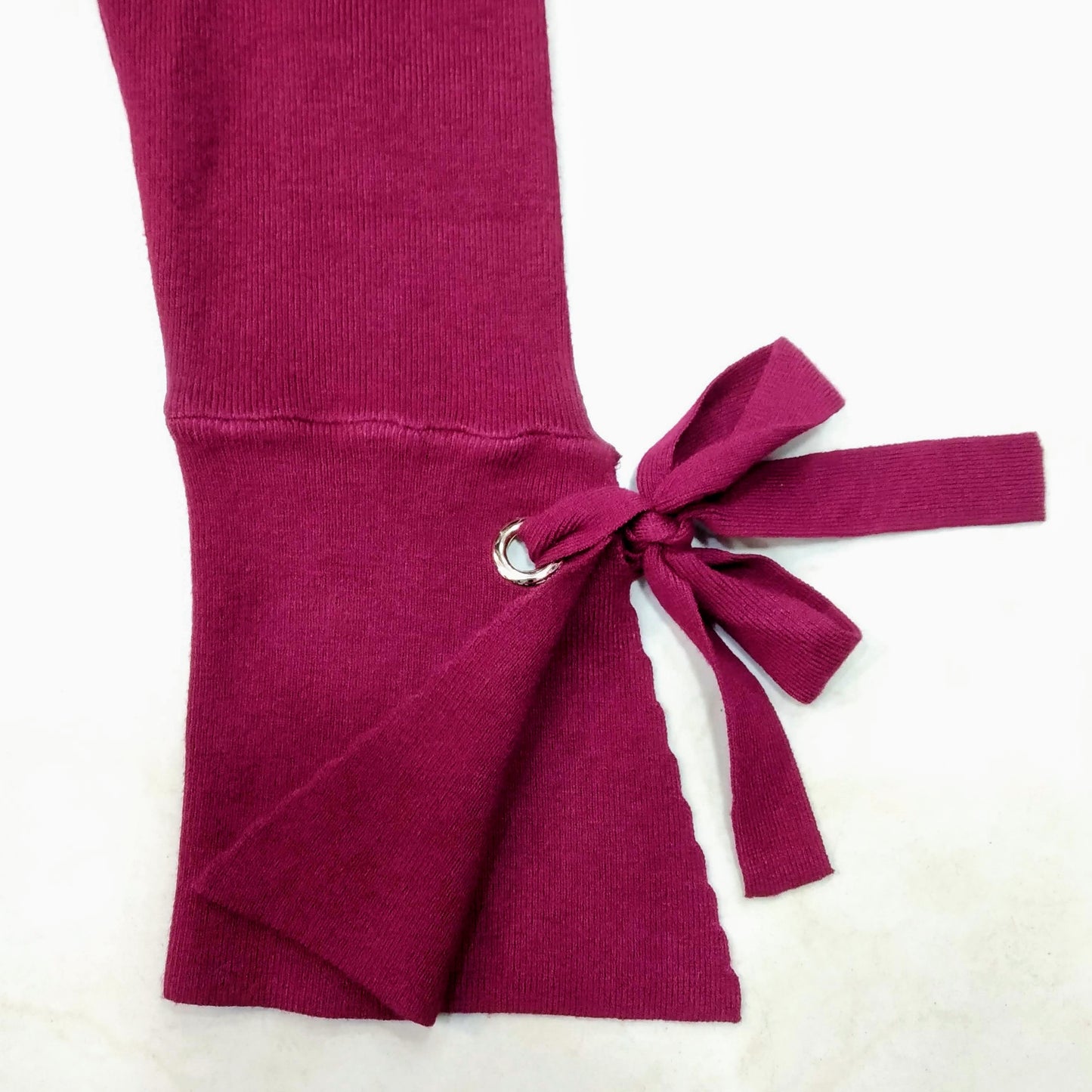 Details of the wrist of the bordeaux fine cotton women sweater, showing a bordeaux knot.. bikinn.com