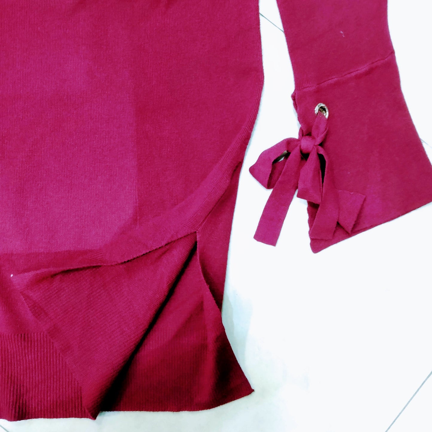 Details of the wrist of the bordeaux fine cotton women sweater, showing a bordeaux knot.. bikinn.com