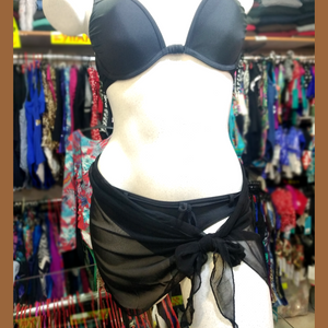 Black mini stretchy pareo in transparent veil, tied around a white mannequin wearing a black push-up bikini set.