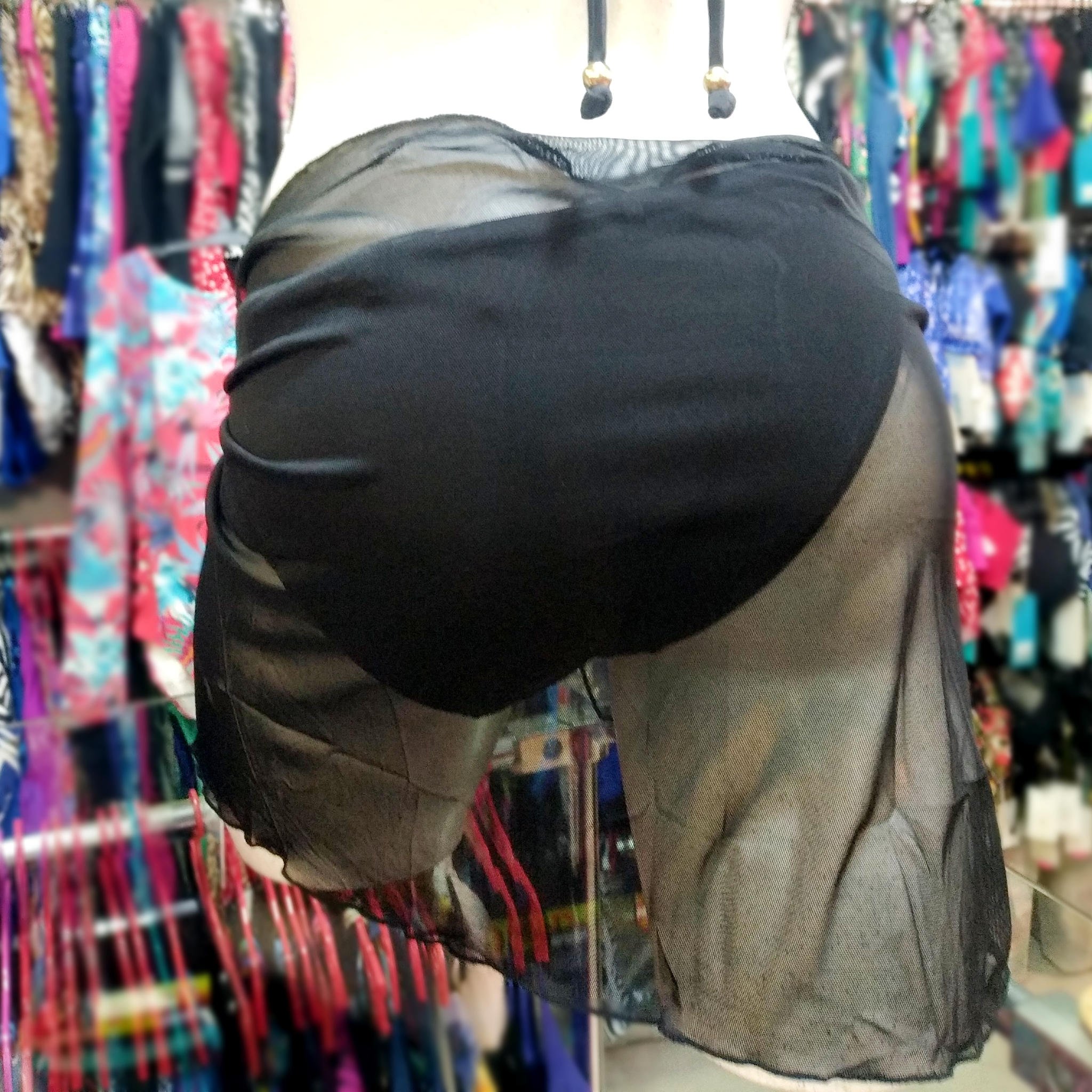 Back view of a black mini stretchy pareo tied around a white mannequin wearing a black  bikini bottom.