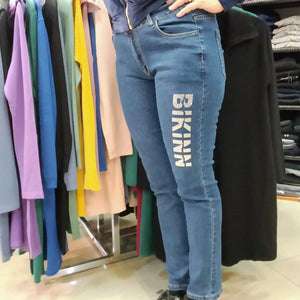 Woman in a skinny strech jeans with a sparkling diamond logo printed on the thigh. bikinn.com
